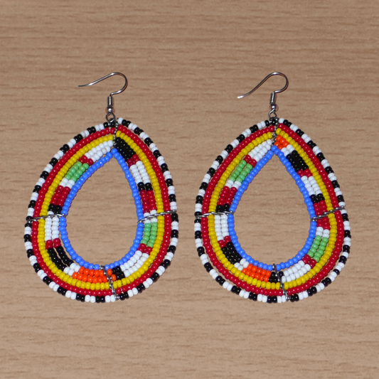 Longues boucles d'oreilles Massai traditionnelles composées de perles de rocaille bleues et multicolores montées en forme de gouttes. Elles mesurent 9 cm de long et 5 cm de large et se portent sur des oreilles percées.