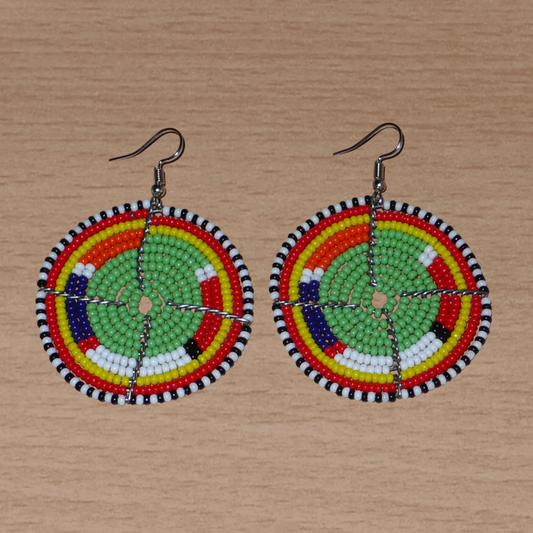 Boucles d'oreilles africaines Massai en perles de rocaille vertes et multicolores enfilées sur des structures circulaires en fils de fer. De taille moyenne, elles mesurent 6,5 cm de long et 4,5 cm de large ; elles se portent sur des oreilles percées.