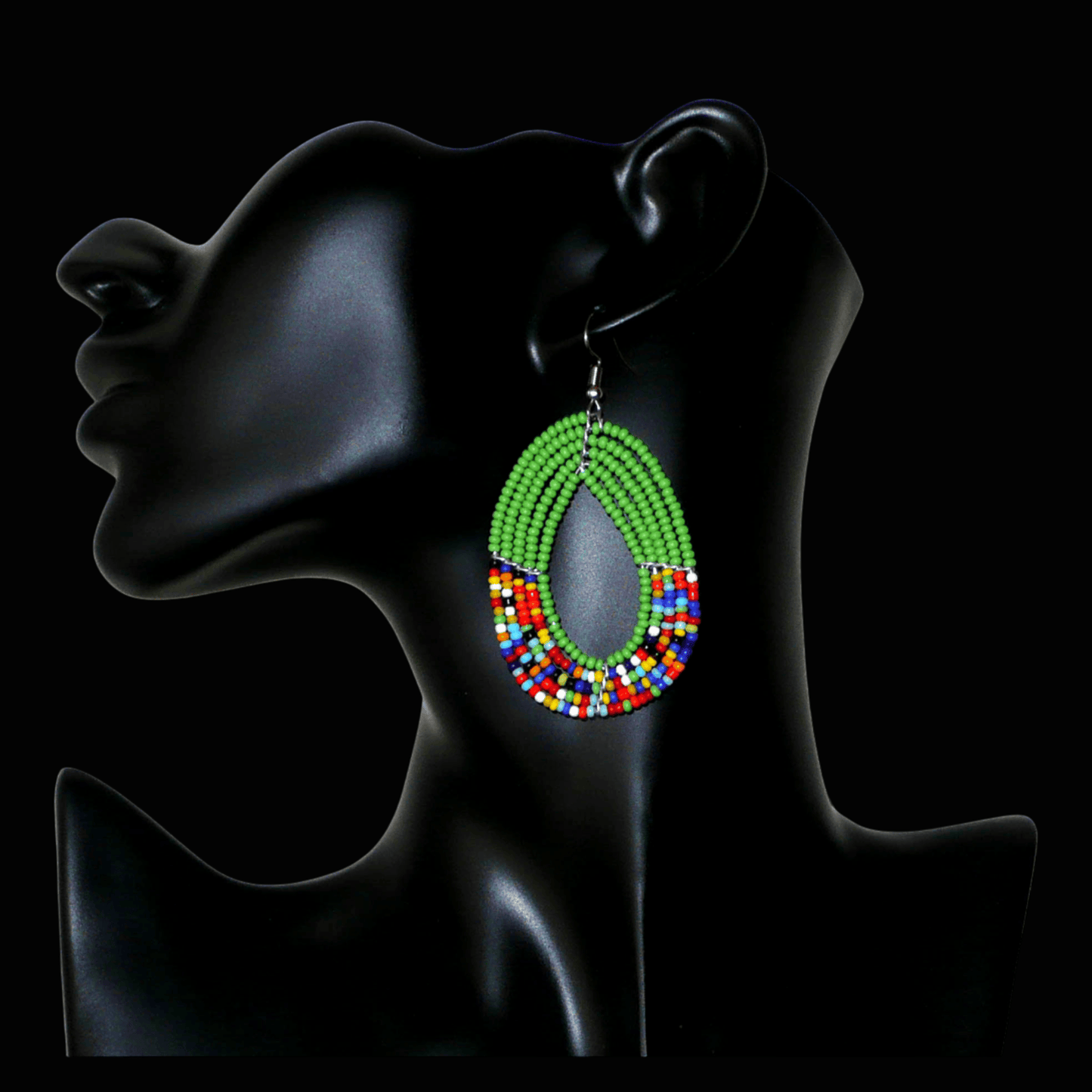 Boucles d'oreilles ethniques multi-rangs vertes et multicolores en forme de gouttes. Elles mesurent 7 cm de long et 4 cm de large et se portent avec des crochets sur des oreilles percées.