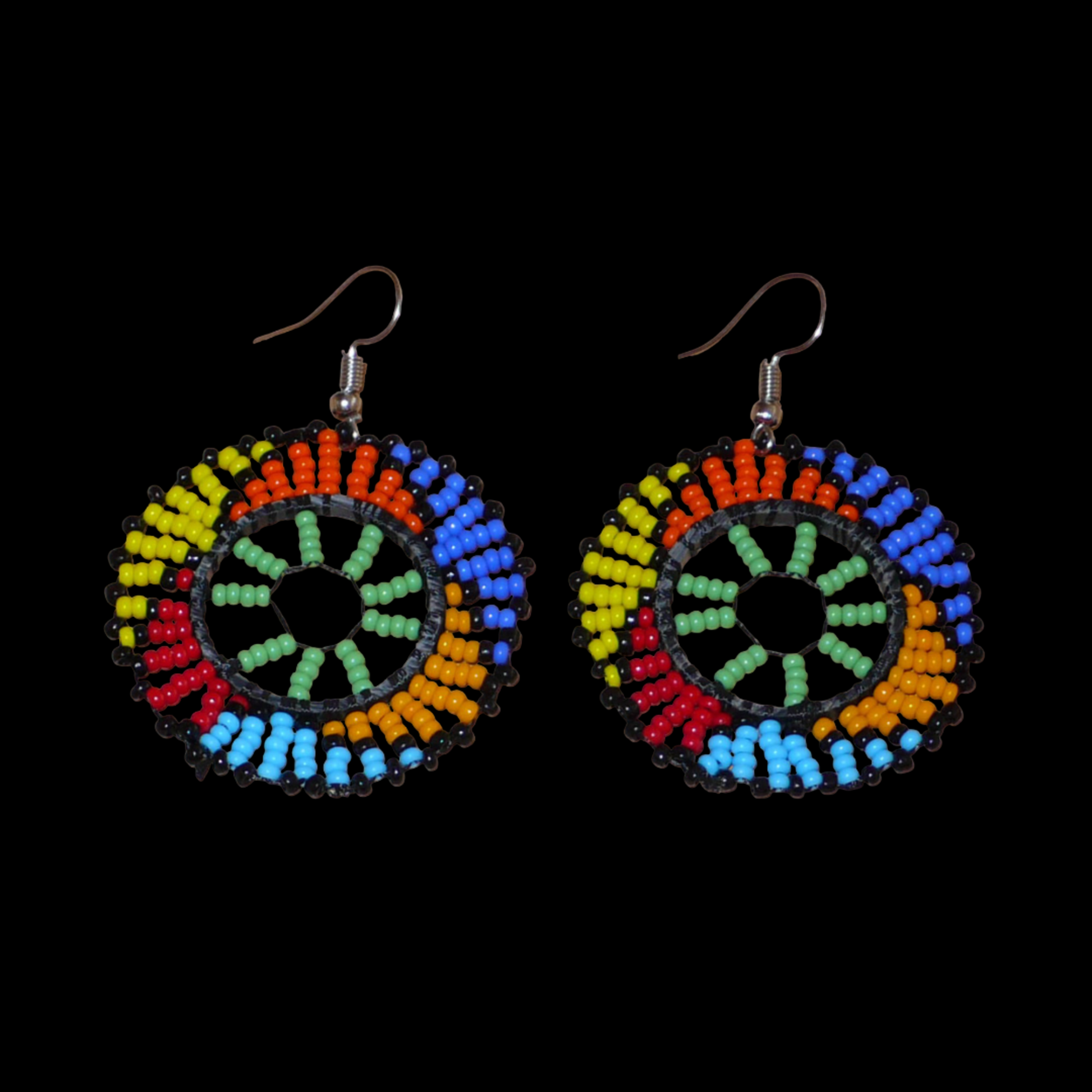 Boucles d'oreilles ethniques rondes à motifs zoulous composées de perles de rocaille vertes et multicolores. De taille moyenne et légères à porter, elles mesurent 6 cm de long et 4 cm de large ; elles se portent avec des crochets en acier inoxydable sur des oreilles percées.