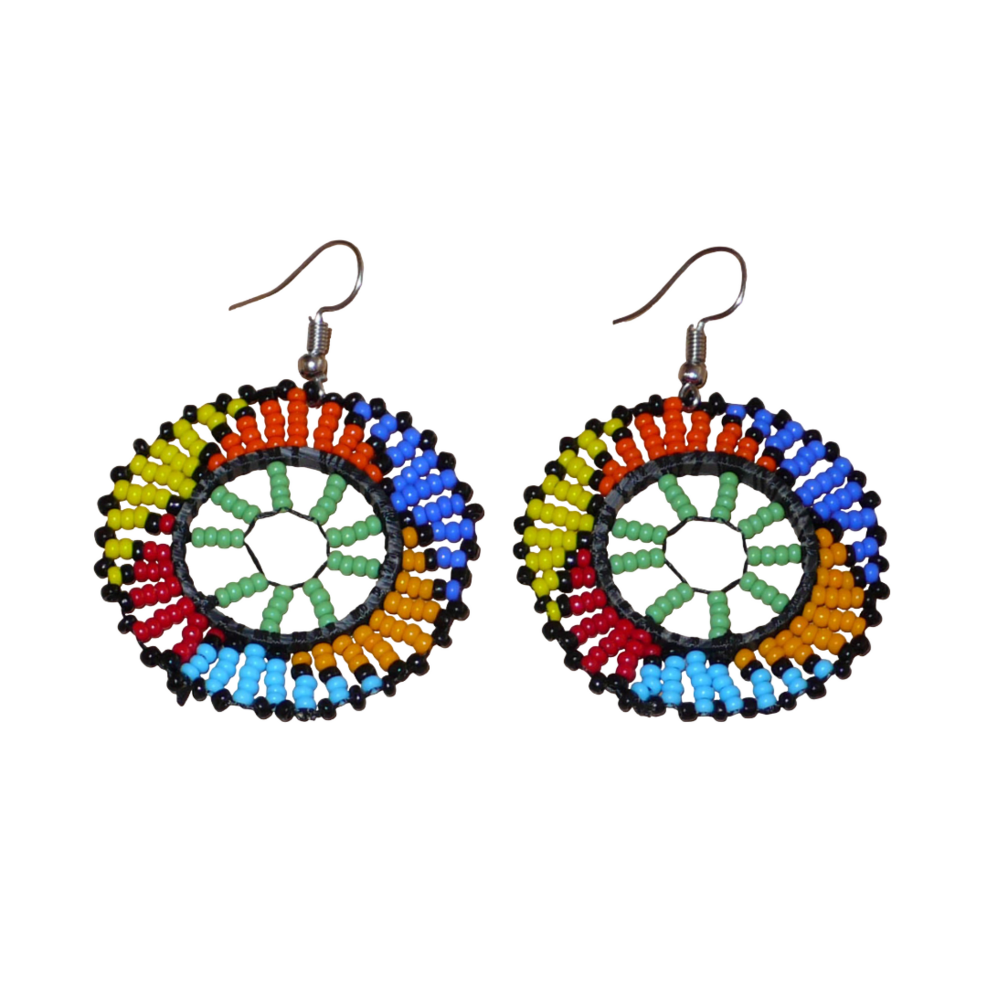 Boucles d'oreilles ethniques rondes à motifs zoulous composées de perles de rocaille vertes et multicolores. De taille moyenne et légères à porter, elles mesurent 6 cm de long et 4 cm de large ; elles se portent avec des crochets en acier inoxydable sur des oreilles percées.