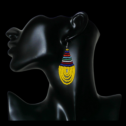 Boucles d'oreilles ethniques jaunes et multicolores composées d'un tissage en forme de gouttes de perles de rocaille. De taille moyenne et légère à porter, elles mesurent 7 cm de long et 2,5 cm de large et se portent avec des crochets en acier inoxydable sur des oreilles percées.