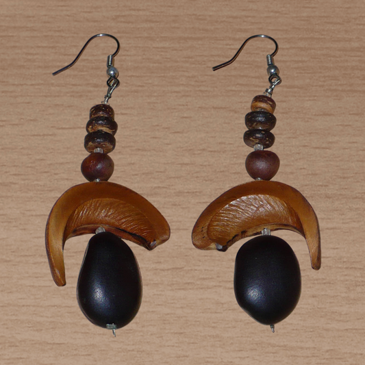 Boucles d'oreilles afro-caribéennes aux accents tropicaux composées de perles et de graines exotiques. Elles mesurent 8.5 cm de long et 3.5 cm de large, et se portent sur des oreilles percées.