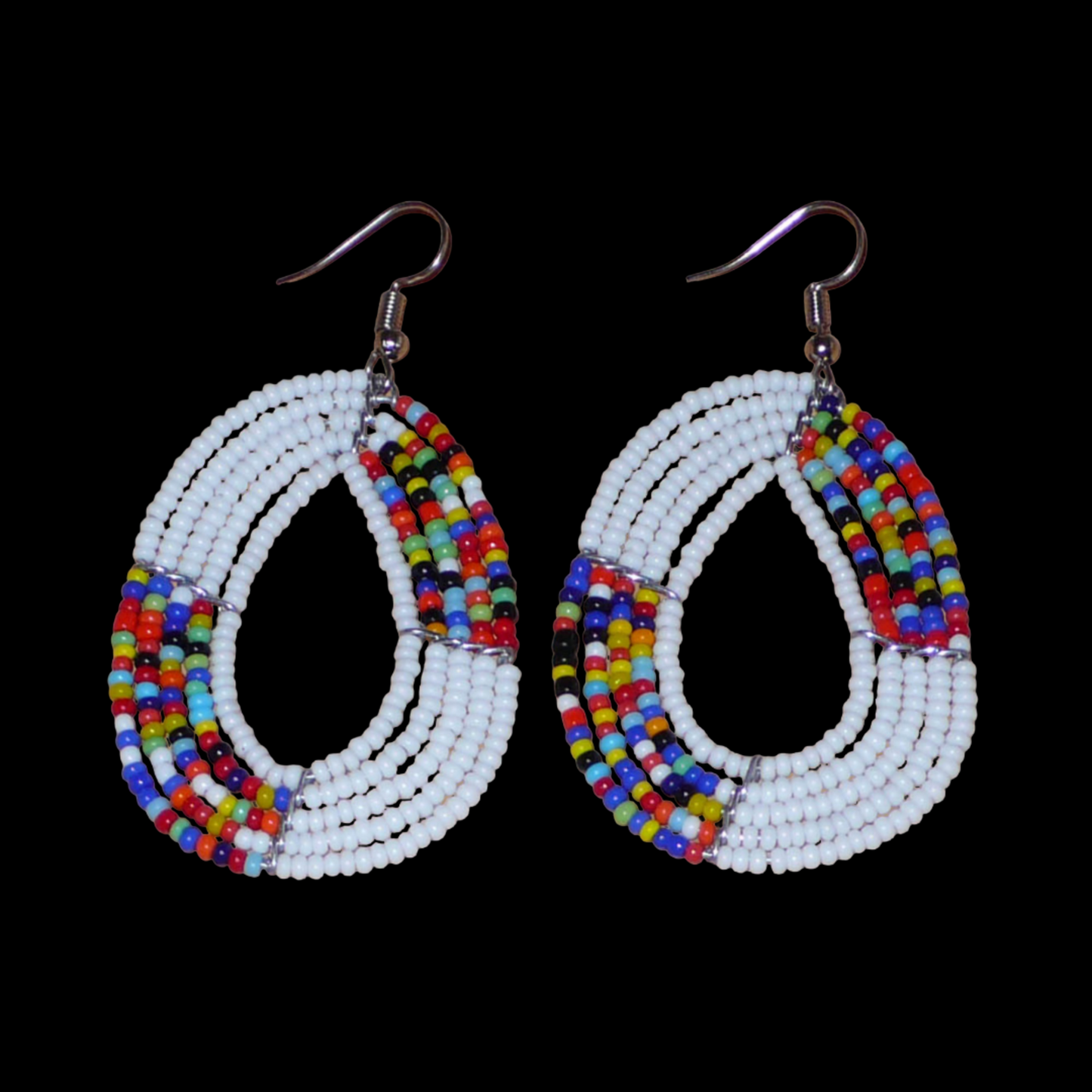 Boucles d'oreilles exotiques multi-rangs en forme de gouttes composées de perles de rocaille blanches et multicolores. De taille moyenne, elles mesurent 7 cm de long et 4 cm de large, et se portent sur des oreilles percées.