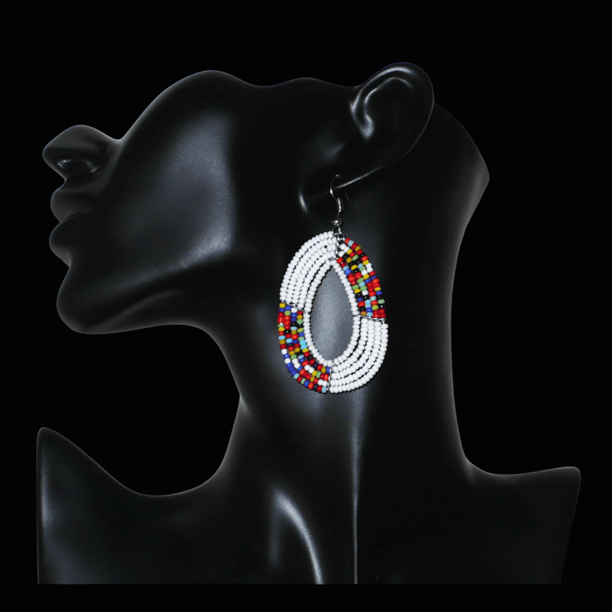 Boucles d'oreilles exotiques multi-rangs en forme de gouttes composées de perles de rocaille blanches et multicolores. De taille moyenne, elles mesurent 7 cm de long et 4 cm de large, et se portent sur des oreilles percées.