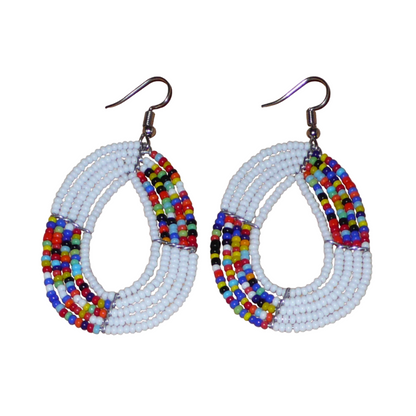 Boucles d'oreilles exotiques multi-rangs en forme de gouttes composées de perles de rocaille blanches et multicolores. De taille moyenne, elles mesurent 7 cm de long et 4 cm de large, et se portent sur des oreilles percées.