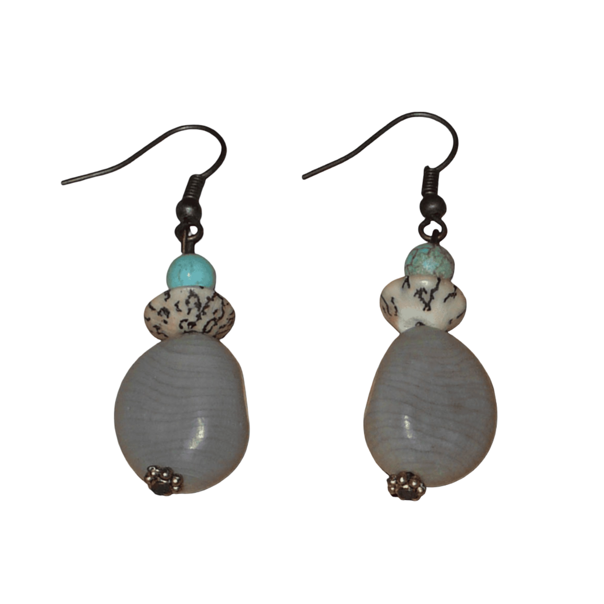 Boucles d'oreilles exotiques composées de perles et de graines de caniques grises. De taille moyenne, elles mesurent 5 cm de long et 1,5 cm de large, et se portent sur des oreilles percées.