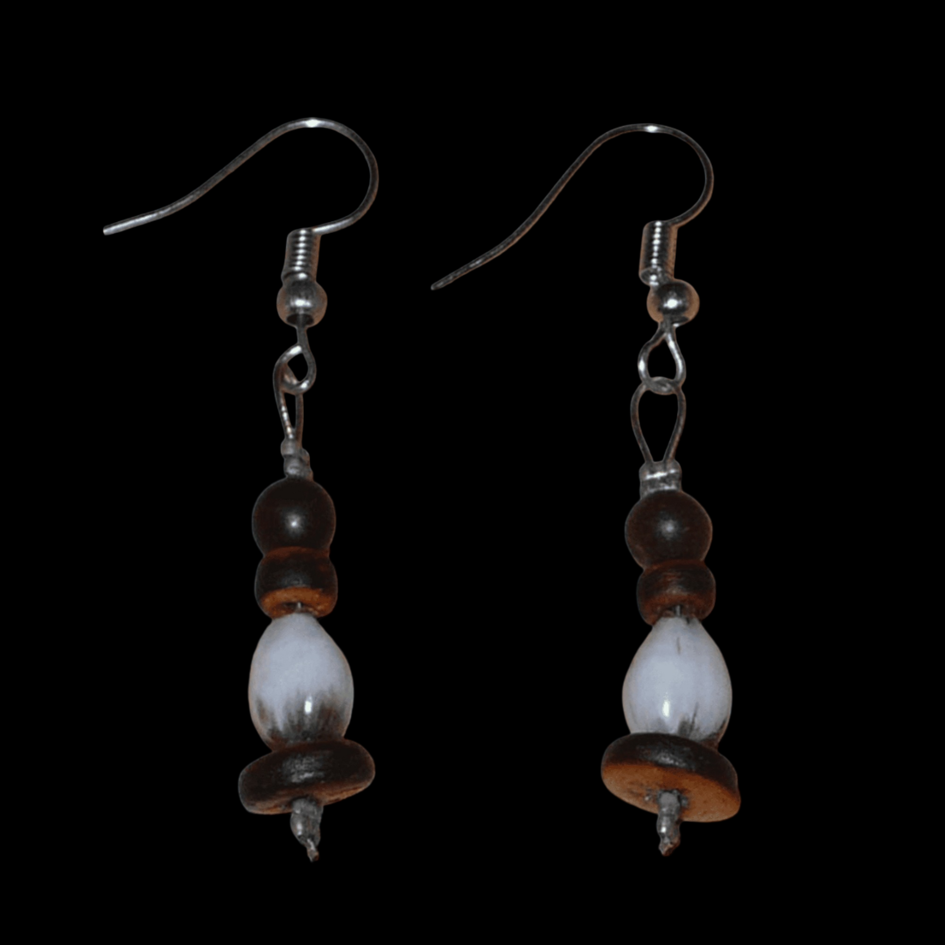 Petites boucles d'oreilles exotiques faites de graines tropicales (larmes de Job et graines de toloman) et de perles en noix de coco. Ces boucles d'oreilles mesurent 5 cm de long et 0,8 cm de large ; elles se portent avec des crochets en acier inoxydable sur des oreilles percées.