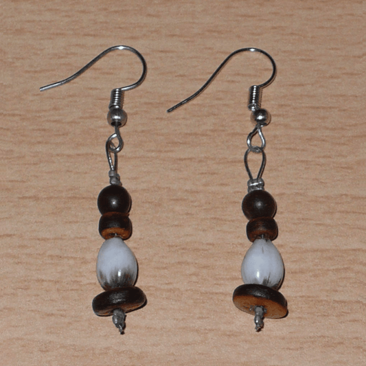 Petites boucles d'oreilles exotiques faites de graines tropicales (larmes de Job et graines de toloman) et de perles en noix de coco. Ces boucles d'oreilles mesurent 5 cm de long et 0,8 cm de large ; elles se portent avec des crochets en acier inoxydable sur des oreilles percées.