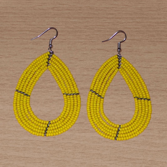 Boucles d'oreilles multi-rangs jaunes faites de perles de rocailles enfilées sur cinq rangées de fils de fer montés en forme de gouttes. Elles mesurent 8 cm de long et 4,5 cm de large et se portent avec des crochets sur des oreilles percées.