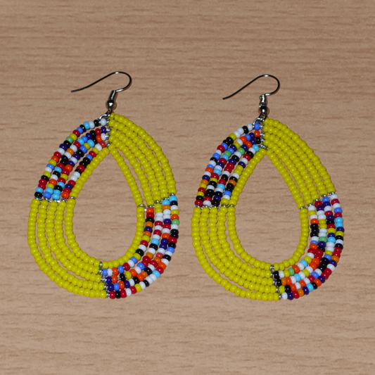 Boucles d'oreilles multi-rangs jaunes et multicolores composées de perles de rocaille montées en forme de gouttes. Elles mesurent 7 cm de long et 4 cm de large et se portent avec des crochets en acier inoxydable sur des oreilles percées.