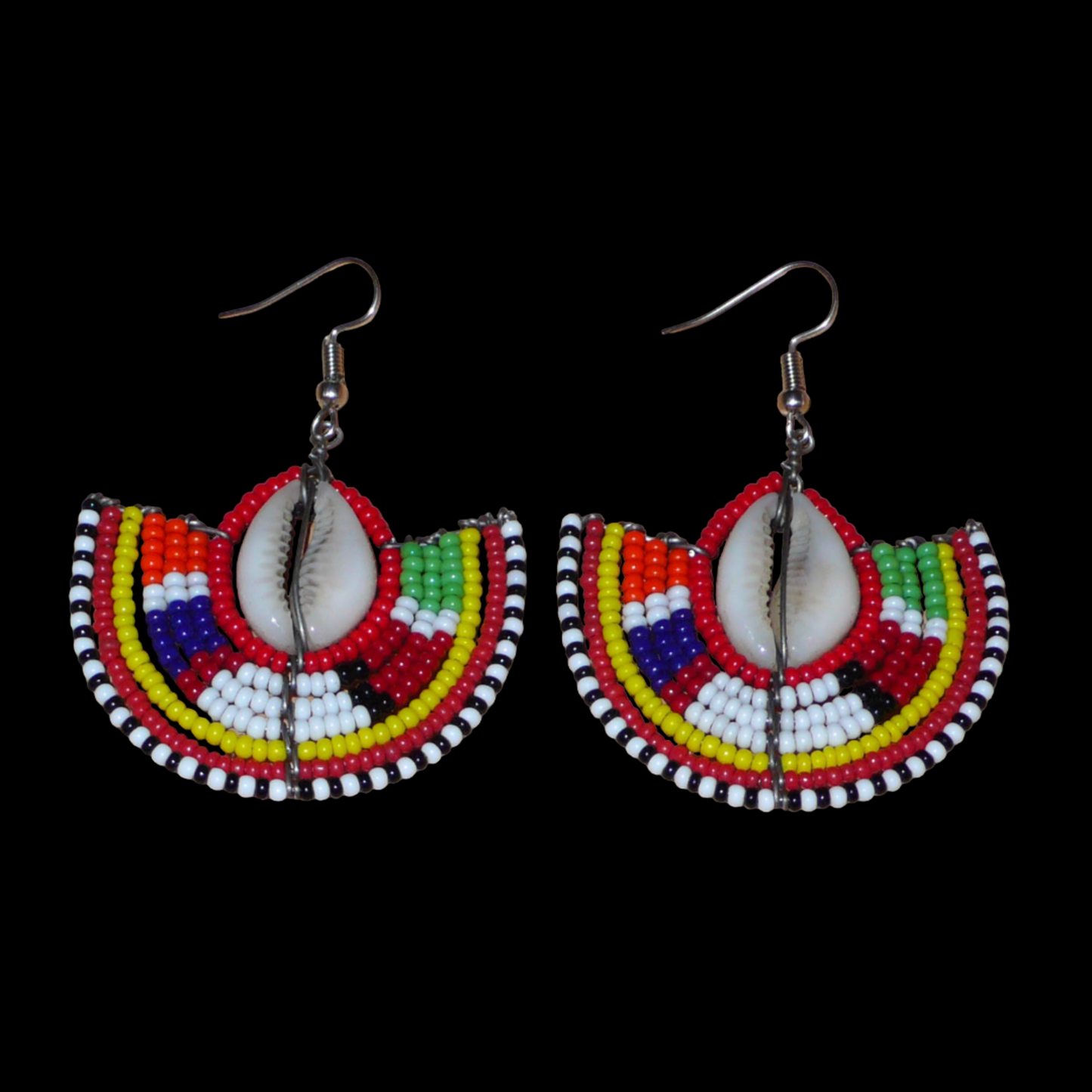 Ajoutez une touche exotique à votre style avec cette jolie paire de boucles d'oreilles africaines issues de l'artisanat traditionnel Massai. Ces boucles d'oreilles ethniques chic se composent de perles de rocaille rouges et multicolores et de coquillages cauris. De taille moyenne, elles mesurent 6 cm de long et 4.5 cm de large, et se portent avec des crochets en acier inoxydable sur des oreilles percées.