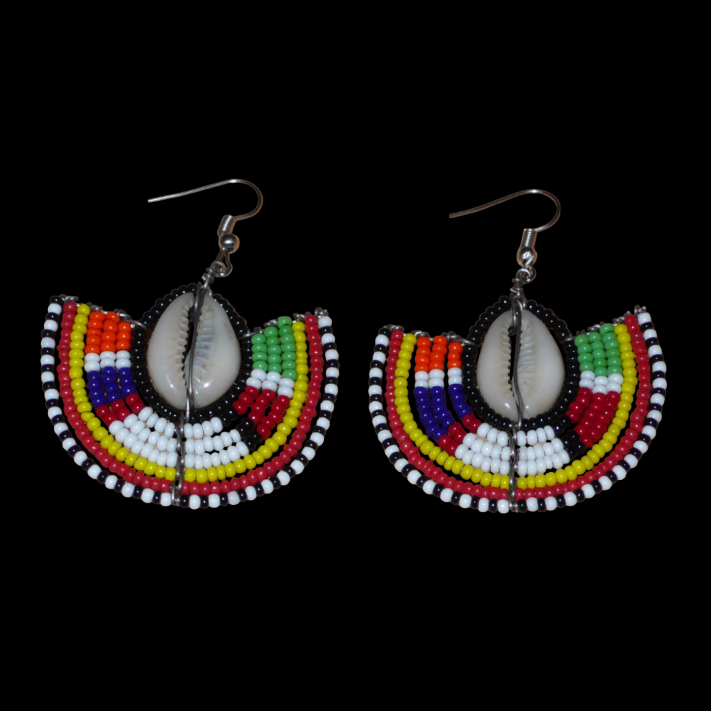 Apportez une note de couleurs à votre look avec cette paire de boucles d'oreilles africaines au style exotique chic issues de l'artisanat traditionnel Massai. Confectionnées à la main au Kenya, ces boucles d'oreilles se composent de perles de rocaille noires et multicolores et de coquillages cauris. De taille moyenne, elles mesurent 6 cm de long et 4.5 cm de large, et se portent avec des crochets en acier inoxydable sur des oreilles percées.