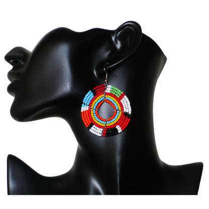 Boucles d'oreilles exotiques rondes aux couleurs rétro évoquant les années 70 composées de perles de rocaille multicolores. Elles mesurent 6.5 cm de long et 4.5 cm de large, et se portent sur des oreilles percées.