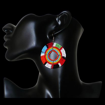 Boucles d'oreilles exotiques rondes aux couleurs rétro évoquant les années 70 composées de perles de rocaille multicolores. Elles mesurent 6.5 cm de long et 4.5 cm de large, et se portent sur des oreilles percées.