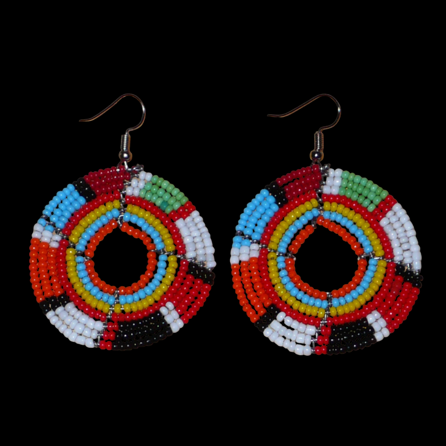 Boucles d'oreilles exotiques rondes aux couleurs rétro évoquant les années 70 composées de perles de rocaille multicolores. Elles mesurent 6.5 cm de long et 4.5 cm de large, et se portent sur des oreilles percées.