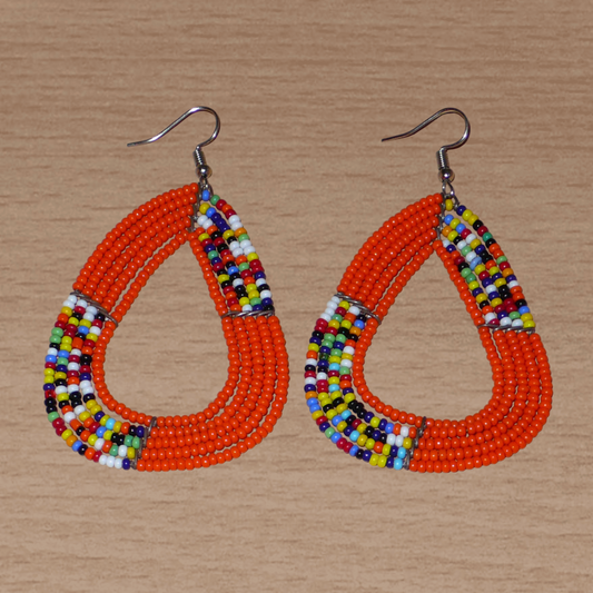Longues boucles d'oreilles africaines multi-rangs aux accents exotiques en perles de rocaille orange et multicolores. Elles mesurent 8 cm de long et 5 cm de large.