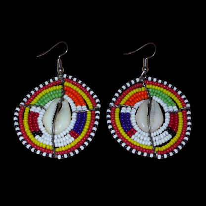 Ambiance traditionnelle Massai avec ce modèle de boucles d'oreilles africaines aux couleurs exotiques et motifs ethniques ! De fabrication tribale artisanale kenyane, elles sont composées de perles de rocaille blanches et multicolores et de coquillages fixés sur des fils de fer montés en forme de boucliers Massai. Ces boucles d'oreilles de taille moyenne mesurent 6.5 cm de long et 4 cm de large, et se portent avec des crochets en acier inoxydable sur des oreilles percées.