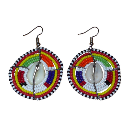 Ambiance traditionnelle Massai avec ce modèle de boucles d'oreilles africaines aux couleurs exotiques et motifs ethniques ! De fabrication tribale artisanale kenyane, elles sont composées de perles de rocaille blanches et multicolores et de coquillages fixés sur des fils de fer montés en forme de boucliers Massai. Ces boucles d'oreilles de taille moyenne mesurent 6.5 cm de long et 4 cm de large, et se portent avec des crochets en acier inoxydable sur des oreilles percées.