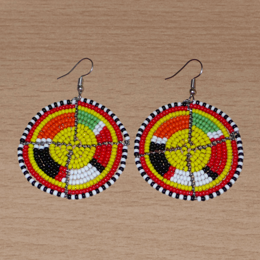 Boucles d'oreilles ethniques rondes à motifs Massai composées de perles de rocaille jaunes et multicolores. De taille moyenne, elles mesurent 6,5 cm de long et 4,5 cm de large, et se portent avec des crochets en acier inoxydable sur des oreilles percées.
