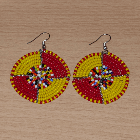 Boucles d'oreilles exotiques ultra colorées en perles de rocaille rouges, jaunes et multicolores montées en forme de disques. Elles mesurent 6 cm de long et 4 cm de large et se portent sur des oreilles percées.