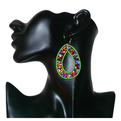 Boucles d'oreilles exotiques vertes et multicolores en forme de gouttes. Elles mesurent 7.5 cm de long et 4 cm de large et se portent sur des oreilles percées.
