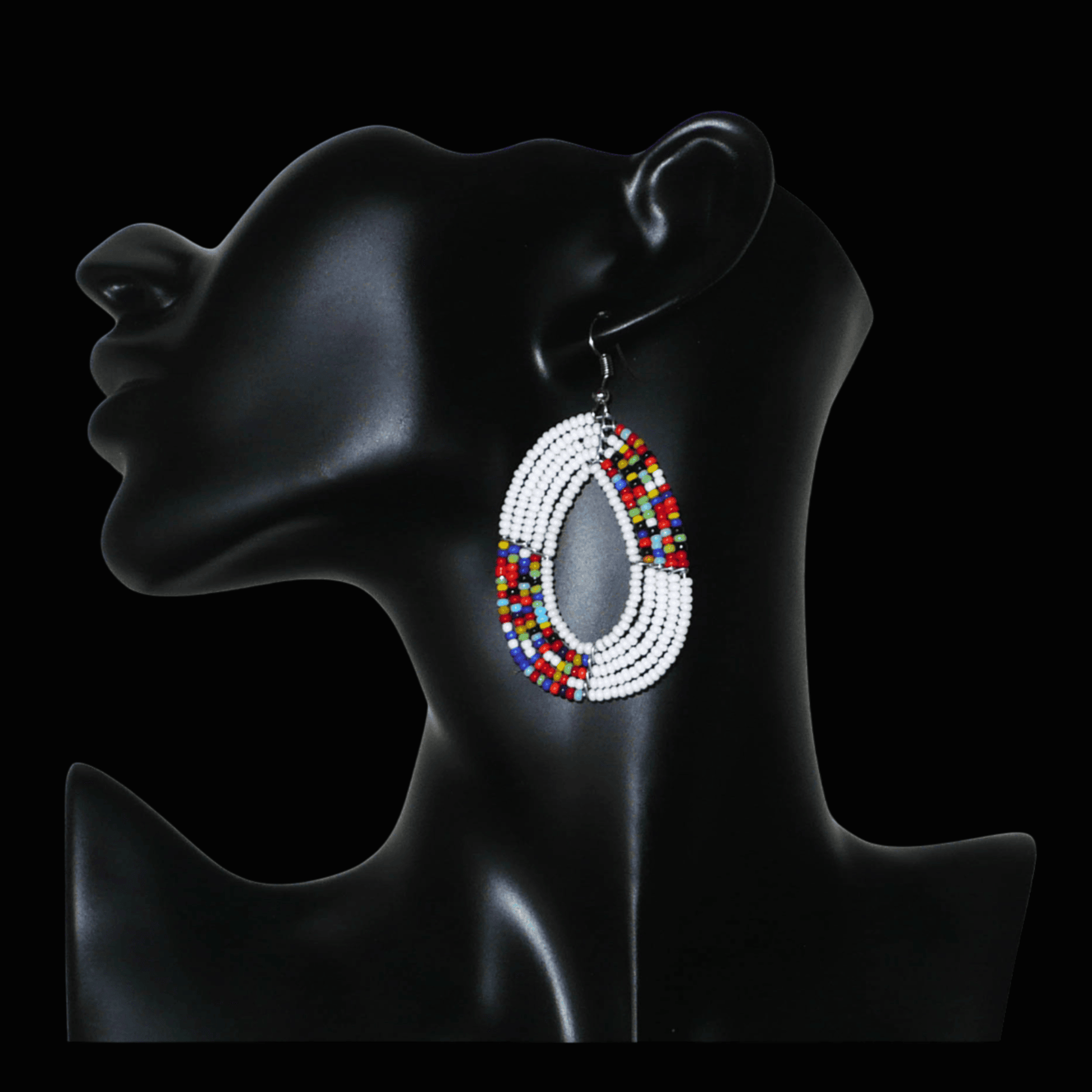 Boucles d'oreilles kenyanes multi-rangs en forme de gouttes composées de perles de rocaille blanches et multicolores. De taille moyenne, elles mesurent 7 cm de long et 4 cm de large, et se portent sur des oreilles percées.