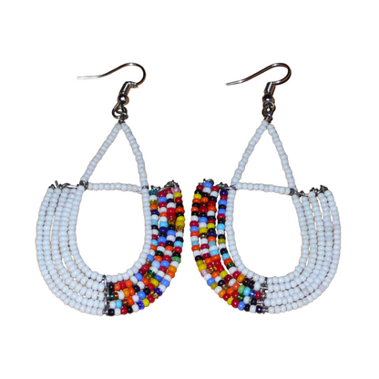 Longues boucles d'oreilles ethniques en forme d'ancres composées de perles de rocaille blanches et d'un mélange de perles multicolores. Ces boucles d'oreilles à l'esprit bohème mesurent 8 cm de long et 4 cm de large et se portent sur des oreilles percées.