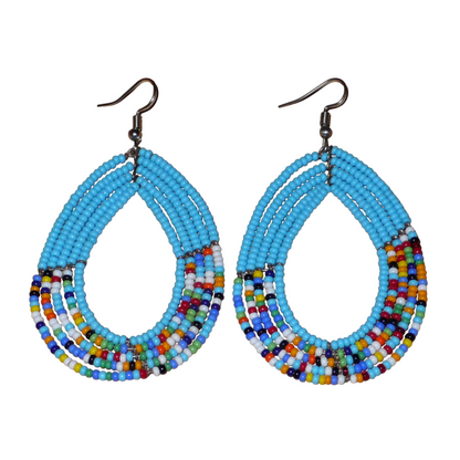Boucles d'oreilles kenyanes en perles de rocaille bleu ciel et multicolores montées en forme de gouttes. Elles mesurent 8 cm de long et 4.5 cm de large, et se portent sur des oreilles percées.