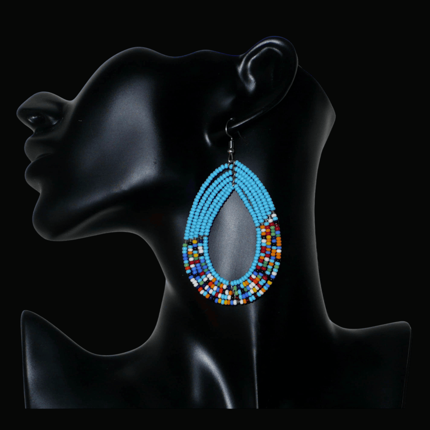 Boucles d'oreilles kenyanes en perles de rocaille bleu ciel et multicolores montées en forme de gouttes. Elles mesurent 8 cm de long et 4.5 cm de large, et se portent sur des oreilles percées.
