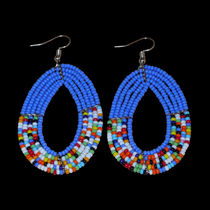 Boucles d'oreilles kenyanes multi-rangs de forme ovales, en perles de rocaille bleues et multicolores. Elles mesurent 7.5 cm de long et 4 cm de large et se portent sur des oreilles percées.