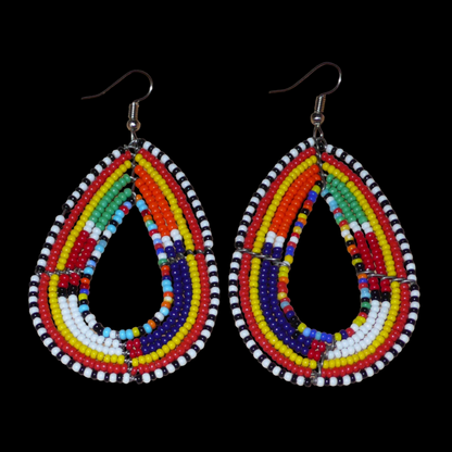 Ajoutez de la couleur à votre look avec ces longues boucles d'oreilles africaines à motifs ethniques traditionnels Massai. Confectionnées selon la tradition artisanale kenyane, elles sont composées de perles de rocaille multicolores glissées sur six rangées de fils de fer montés en forme de gouttes. Ces boucles d'oreilles mesurent 8 cm de long et 4.5 cm de large ; elles se portent avec des crochets en acier inoxydable sur des oreilles percées.