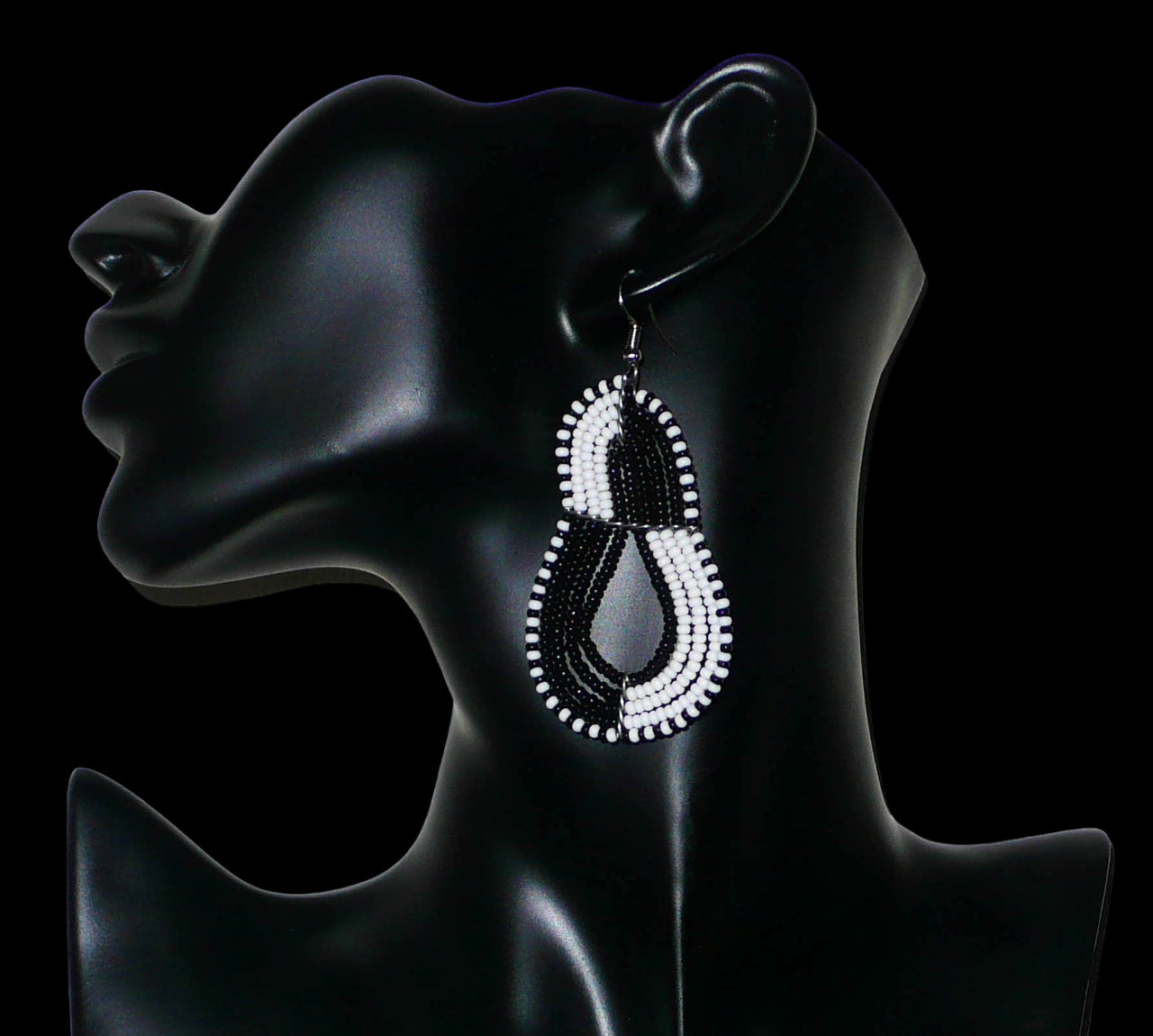 Bijoux noirs et blancs. Boucles d'oreilles kenyanes bicolores composées de perles de rocaille noires et blanches enfilées sur cinq fils de fer montés en forme de poires. Elles mesurent 8 cm de long et 3,8 cm de large et se portent sur des oreilles percées. Timeless Fineries