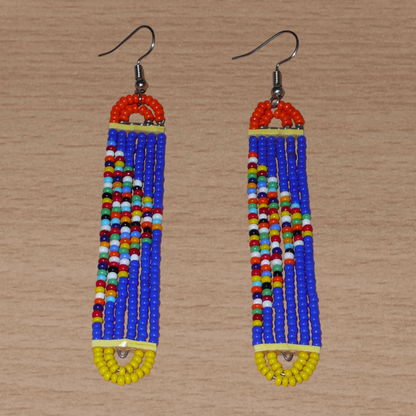 Longues boucles d'oreilles kenyanes en perles de rocaille bleues, orange, jaunes et multicolores glissées sur six rangées de fils de fer montés en forme de rectangles aux bouts arrondis. Elles mesurent 9,5 cm de long et 1,5 cm de large et se portent sur des oreilles percées.