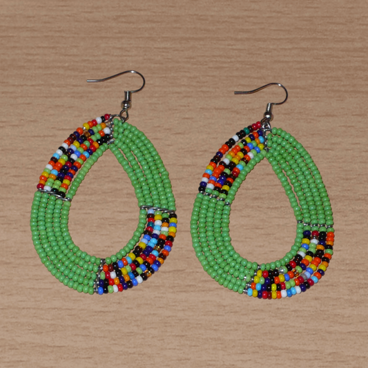 Boucles d'oreilles kenyanes vertes et multicolores en perles de rocaille enfilées sur cinq rangées de fils de fer montés en forme de gouttes. Elles mesurent 8 cm de long et 4.5 cm de large, et se portent sur des oreilles percées.