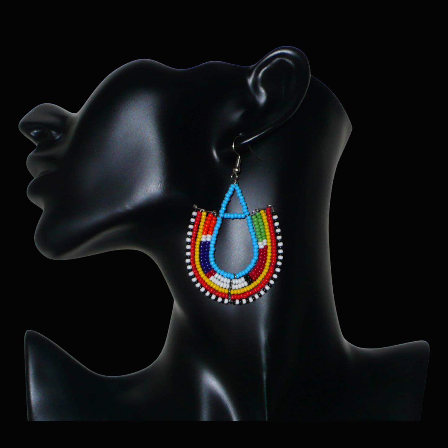 Cette paire de boucles d'oreilles africaines traditionnelles Massai en forme d'ancres, de conception artisanale kenyane, apportera une touche ethnique à votre look ! D'allure exotique et riches en couleurs, elles se composent de perles de rocaille bleues et multicolores glissées sur des structures géométriques en fils de fer montés en forme d'ancres. Ces boucles d'oreilles mesurent 7.5 cm de long et 4.5 cm de large, et se portent avec des crochets en acier inoxydable sur des oreilles percées.