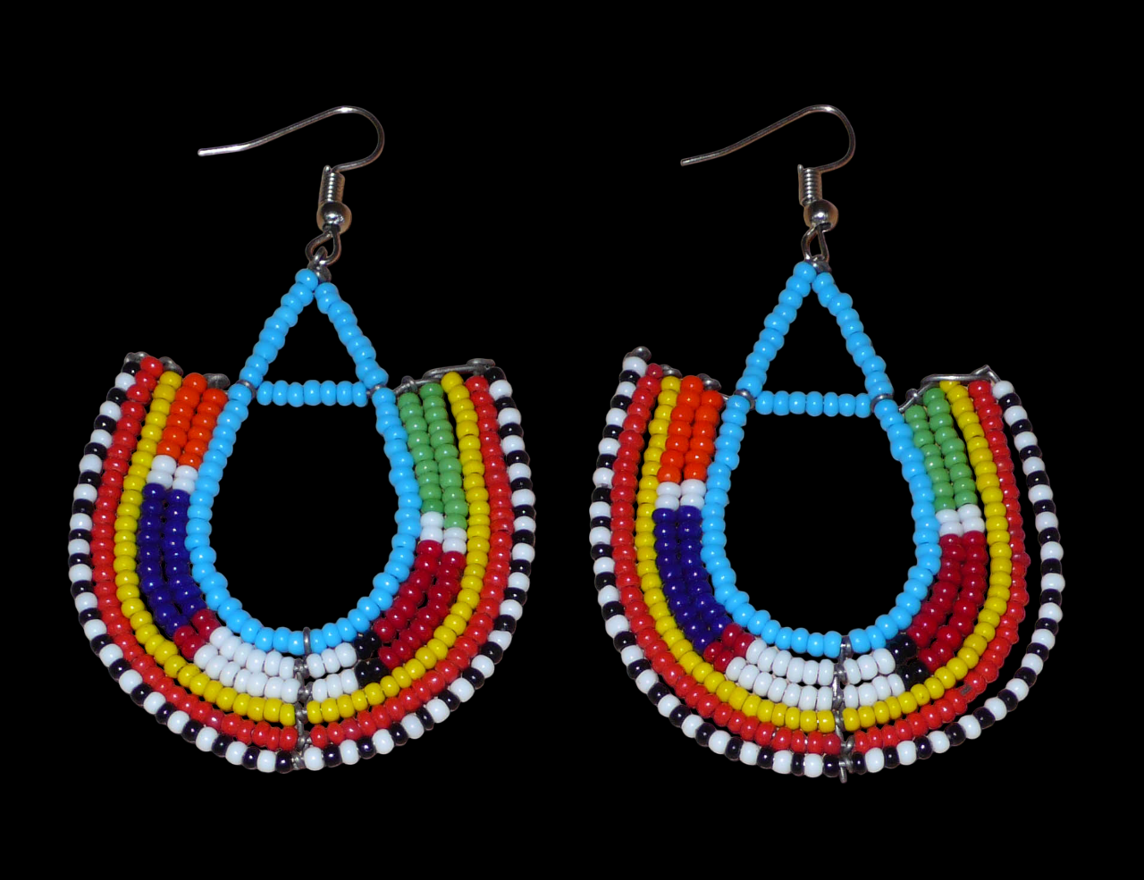 Cette paire de boucles d'oreilles africaines traditionnelles Massai en forme d'ancres, de conception artisanale kenyane, apportera une touche ethnique à votre look ! D'allure exotique et riches en couleurs, elles se composent de perles de rocaille bleues et multicolores glissées sur des structures géométriques en fils de fer montés en forme d'ancres. Ces boucles d'oreilles mesurent 7.5 cm de long et 4.5 cm de large, et se portent avec des crochets en acier inoxydable sur des oreilles percées.
