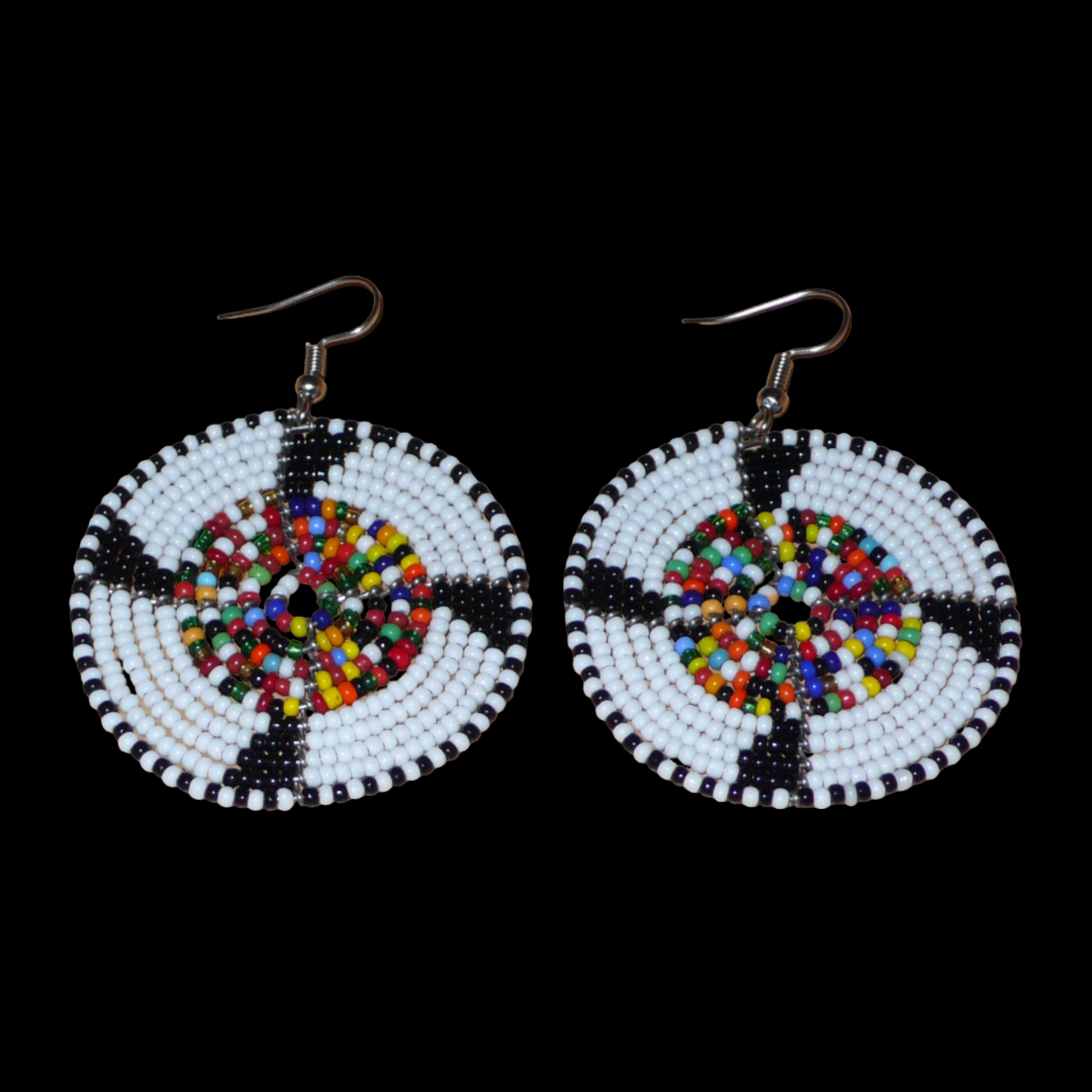 Ajoutez une touche ethnique à votre style avec ces boucles d'oreilles africaines rondes confectionnées dans la tradition artisanale Massai. Elles se composent de perles de rocaille principalement blanches, puis noires et multicolores glissées sur des structures circulaires en fils de fer. Cette paire de boucles d'oreilles mesure 6.5 cm de long et 4.5 cm de large, et se porte avec des crochets en acier inoxydable sur des oreilles percées.