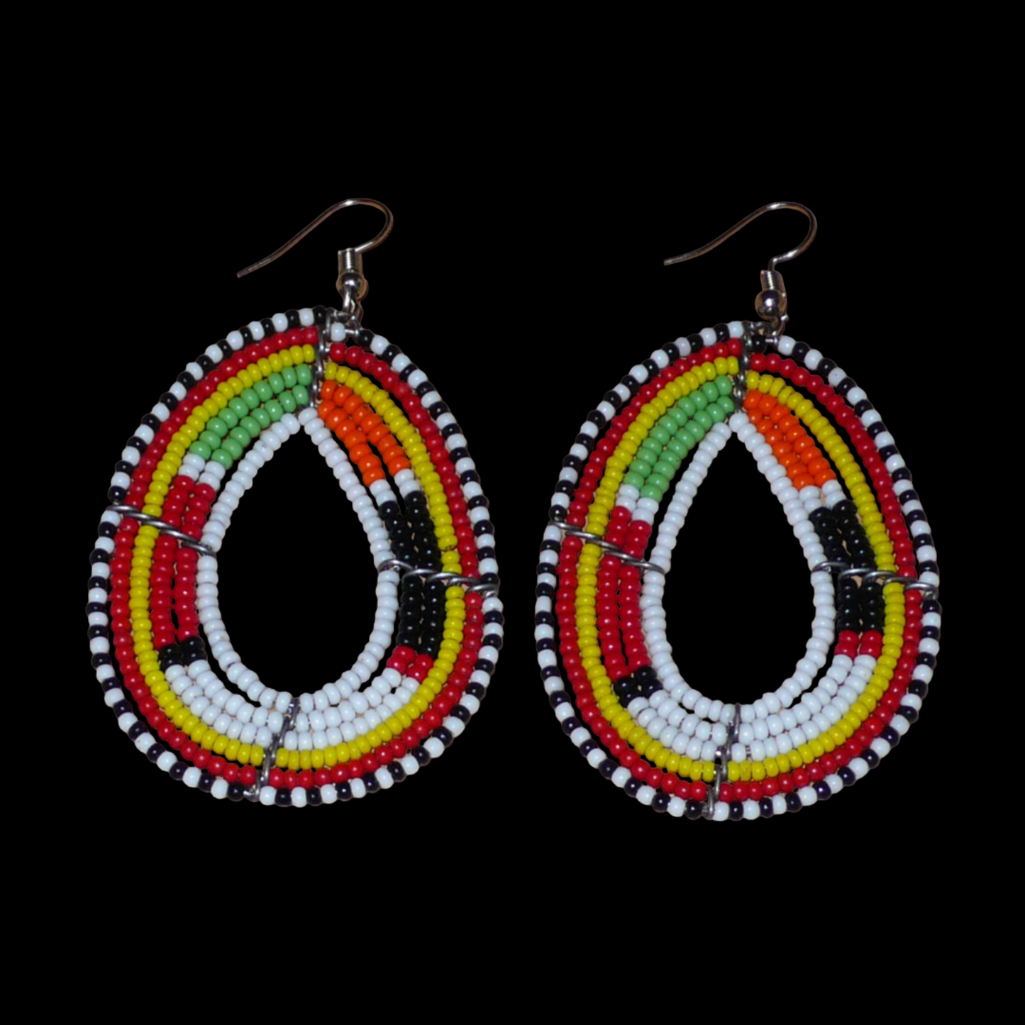 Boucles d'oreilles Massai multi-rangs blanches et multicolores faites de perles de rocaille montées en forme de gouttes. Elles mesurent 7. cm de long et 4 cm de large, et se portent sur des oreilles percées.