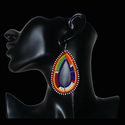 Boucles d'oreilles africaines Massai bleu marine et multicolores en forme de gouttes. Elles mesurent 8.5 cm de long et se portent sur des oreilles percées.