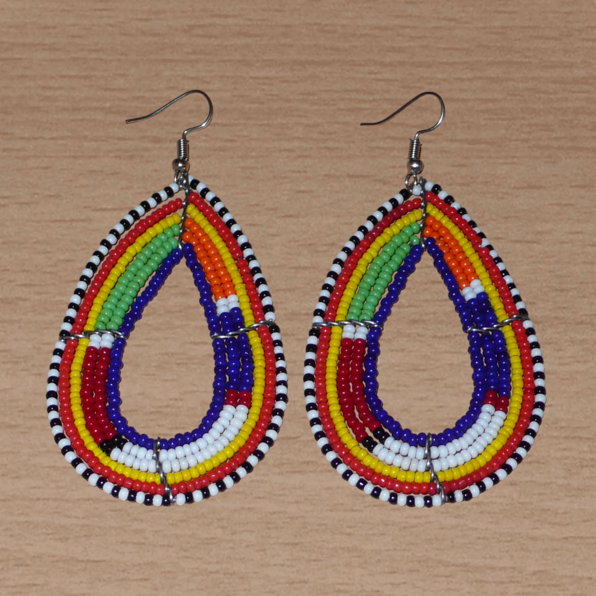 Boucles d'oreilles africaines Massai bleu marine et multicolores en forme de gouttes. Elles mesurent 8.5 cm de long et se portent sur des oreilles percées.