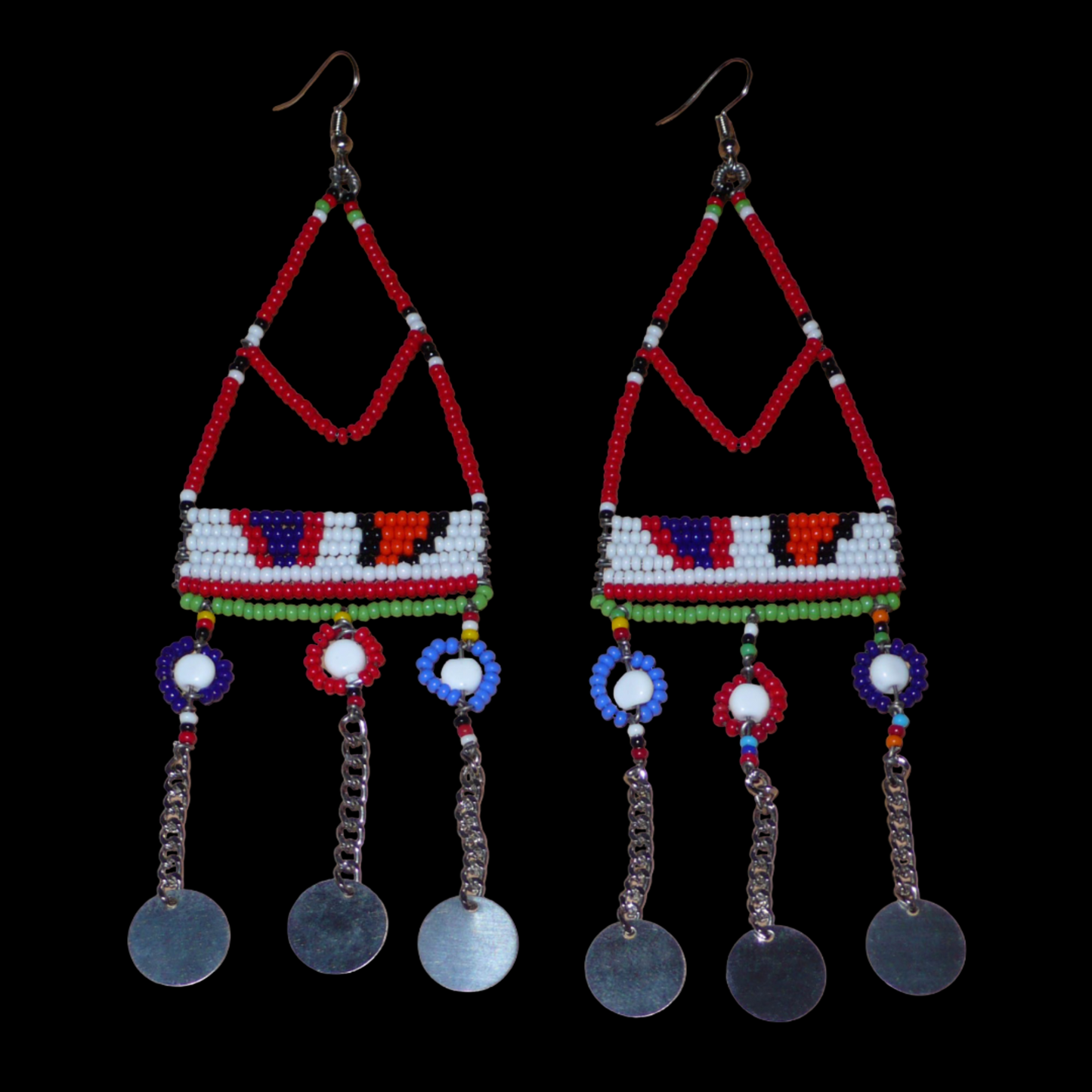 Ajoutez une touche ethnique à votre look avec ces superbes boucles d'oreilles africaines Massai rouges et multicolores fabriquées dans la plus pure tradition artisanale kenyane. Elles se composent de perles de rocaille rouges et multicolores et de perles en plastique enfilées sur des structures à formes géométriques en fils de fer, et se prolongent de chaînettes décorées de disques métalliques. Surdimensionnées, elles mesurent 15.5 cm de long.