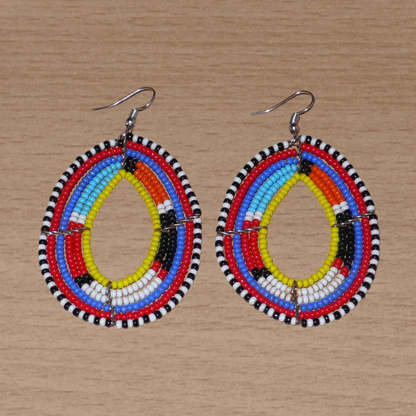 Boucles d'oreilles ethniques Massai faites de perles de rocaille multicolores montées en forme de gouttes. Elles mesurent 8 cm de long et 4.5 cm de large et se portent sur des oreilles percées.
