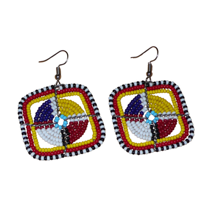 Boucles d'oreilles africaines de tradition ethnique Massai composées de perles de rocaille multicolores enfilées sur des structures géométriques en fils de fer. Ces boucles d'oreilles colorées aux accents exotiques mesurent 5.5 cm de long et 4.5 cm de large ; elles se portent avec des crochets en acier inoxydable sur des oreilles percées.