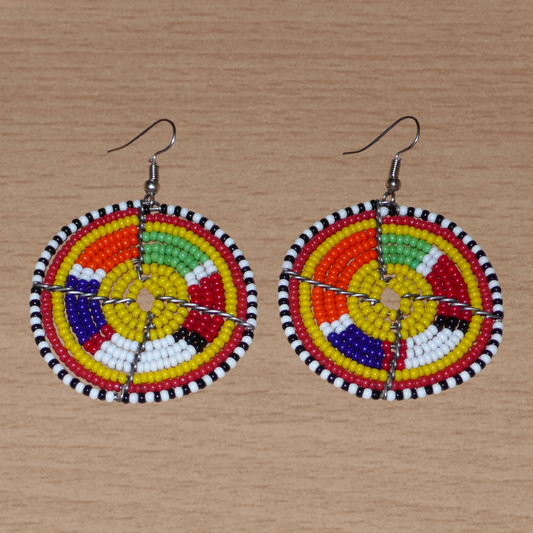 Boucles d'oreilles africaines rondes jaunes et multicolores de tradition ethnique artisanale Massai : elles se composent de perles de rocaille enfilées sur des structures circulaires en fils de fer. Ces boucles d'oreilles aux accents exotiques mesurent 6.5 cm de long et 4.5 cm de large ; elles se portent avec des crochets en acier inoxydable sur des oreilles percées.