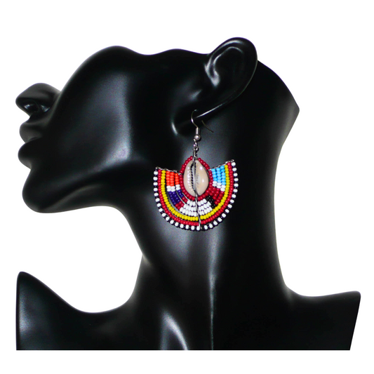 Ajoutez une touche exotique à votre look avec cette paire de boucles d'oreilles africaines Massai au style ethnique afro chic ! De confection artisanale kenyane, ces boucles d'oreilles se composent d'un tissage de perles de rocaille rouges et multicolores et de coquillages. De taille moyenne, elles mesurent 6 cm de long et 4.5 cm de large, et se portent avec des crochets en acier inoxydable sur des oreilles percées.