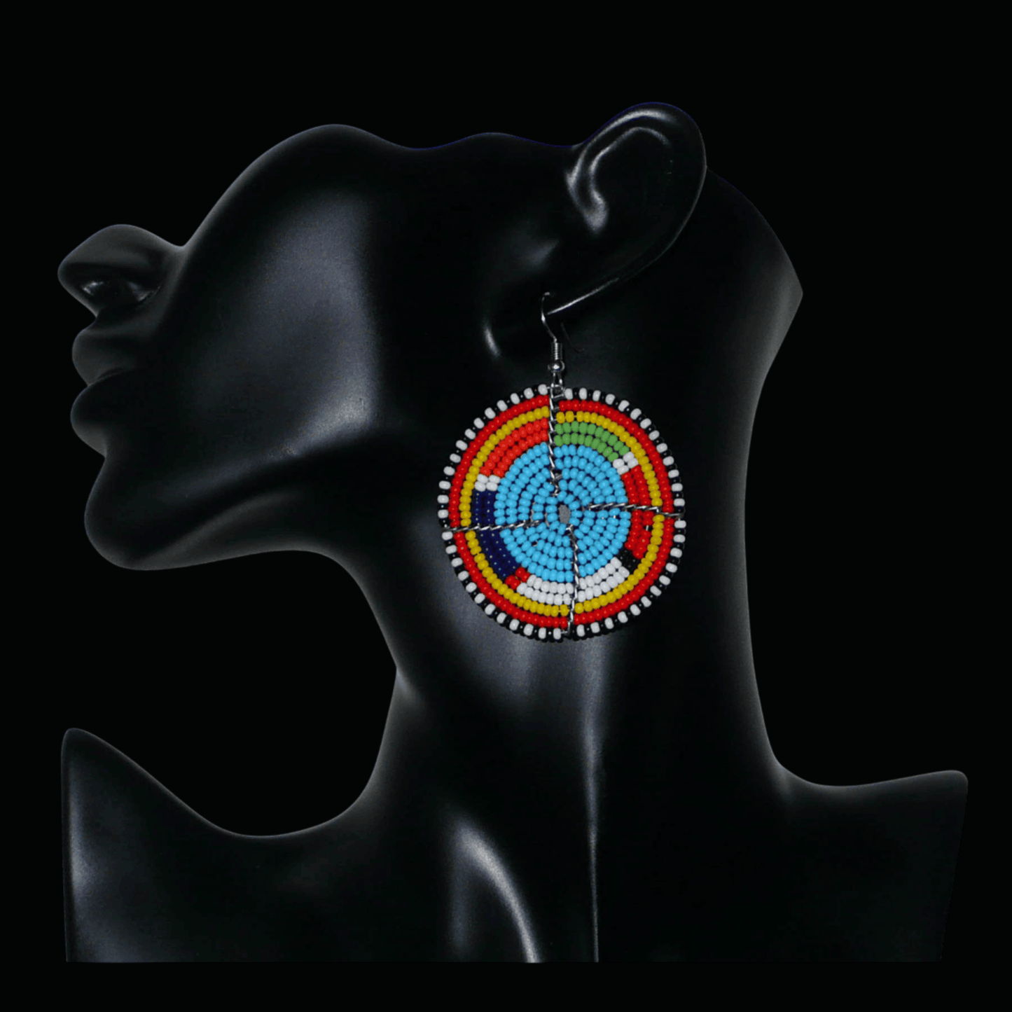 Boucles d'oreilles africaines rondes à motifs ethniques Massai composées de perles de rocaille bleues et multicolores. Elles mesurent 6.5 cm de long et 5 cm de large, et se portent sur des oreilles percées.