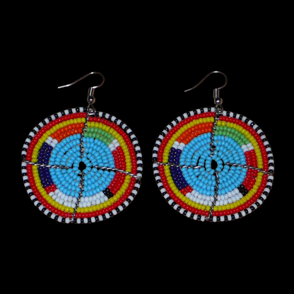 Boucles d'oreilles africaines rondes à motifs ethniques Massai composées de perles de rocaille bleues et multicolores. Elles mesurent 6.5 cm de long et 5 cm de large, et se portent sur des oreilles percées.