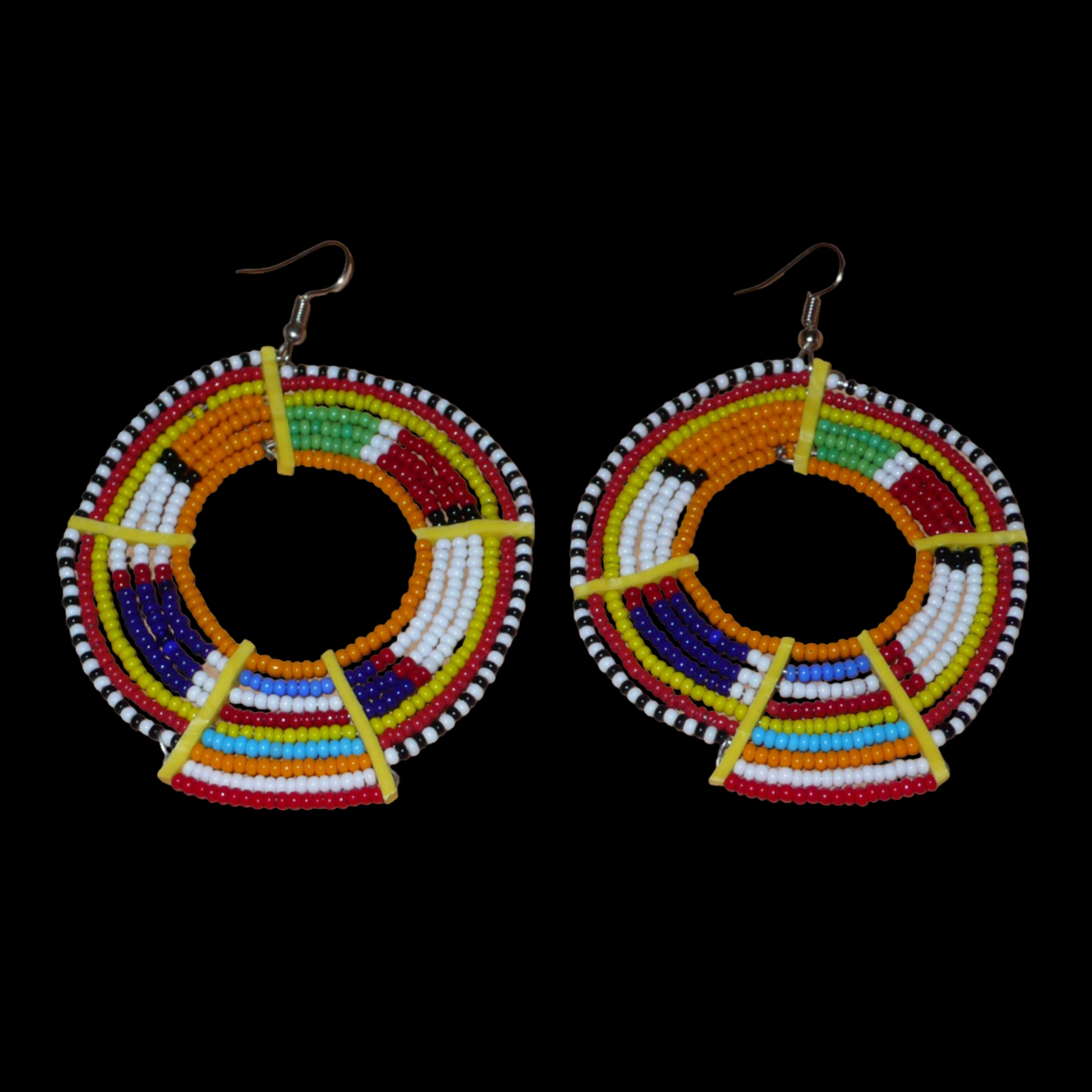Boucles d'oreilles africaines tribales surdimensionnées, fabriquées au Kenya dans la plus pure tradition artisanale Massai. Elles se composent de perles de rocaille orange et multicolores tissées sur des structures circulaires en fils de fer fixés à des charnières en plastique jaune. Ces longues et larges boucles d'oreilles ethniques mesurent 8.5 cm de long et 6 cm de large ; elles se portent avec des crochets en acier inoxydable sur des oreilles percées.
