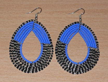 Longues boucles d'oreilles multi-rangs composées de perles de rocaille bleues, noires et gris nacré ; elles mesurent 8 cm de long et 5 cm de large et se portent avec des crochets sur des oreilles percées.
